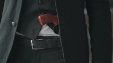 Resmi takım elbiseli adam ve kemerinde bir silah yakın çekim