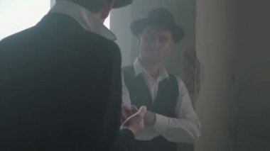 Portre fedora şapkalı iki yetişkin erkek kırık durty yerde ayakta ve konuşuyor. Terk edilmiş harap bina. Kendine güvenen bir işadamı rahatlatıcı. Mafya klanı. Suç gruplandırma.