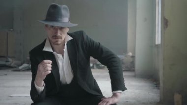 Terk edilmiş bir binada oturan parmaklarda sikke dönüm bir şapka içinde Portre yakışıklı kendine güvenen adam. Mafyanın başı boş bir odada bekliyor. Ceza dairesi portresi