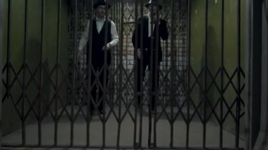 Resmi takım elbiseli iki gangster ve metal sahte kapılar açan fedora şapkası