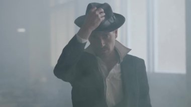 Klasik eski moda takım elbiseiçinde, şapka tutan ve kameraya güvenle bakan başarılı bir beyefendinin portresi. Ceza dairesi portresi. Kendine güvenen işadamı rahatlatıcı