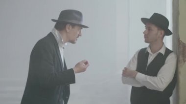 Portre iki yetişkin emin erkek fedora şapka kırık durty yerde ayakta ve konuşuyor. Terk edilmiş harap bina. Kendine güvenen bir işadamı rahatlatıcı. Mafya klanı. Suç gruplandırma.