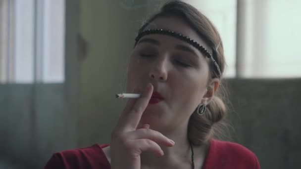 Close-up portret zelfverzekerde jonge vrouw in stijl doek staan en roken van de sigaret. Verlaten vervallen gebouw. — Stockvideo