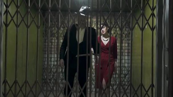 Den höga mannen i kostym och hatt öppnar dörren och passerar inne i mörkret rummet en säker vacker flicka i en elegant röd klänning. Retro, Vintage stil. Mafia Life — Stockvideo