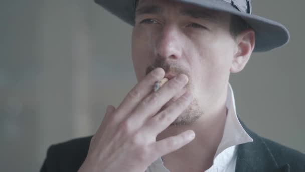 Portret vertrouwen Noir detective of maffiabaas en gangster roken van een sigaret of sigaar. Strafrechtelijke instantie portret. Zelfverzekerde zakenman ontspannend. — Stockvideo