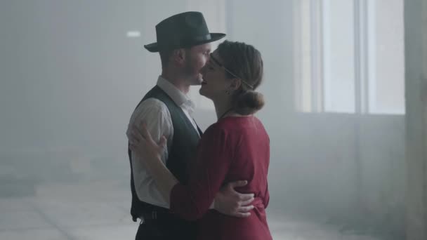 Porträt Mann mit Fedora-Hut, klassischen Anzügen und Frau in stilvollem Tuch tanzen in verlassenem Gebäude. — Stockvideo