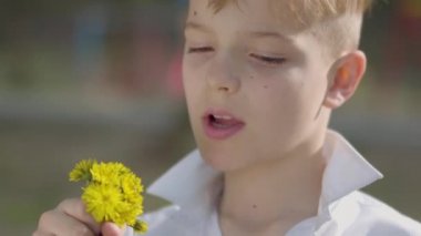 Portre genç sevimli çocuk parkta bir karahindiba çiçek kokulu