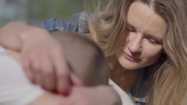Le jeune garçon pleure et sa mère apaise son fils à l'extérieur. Relation mère et fils . — Video