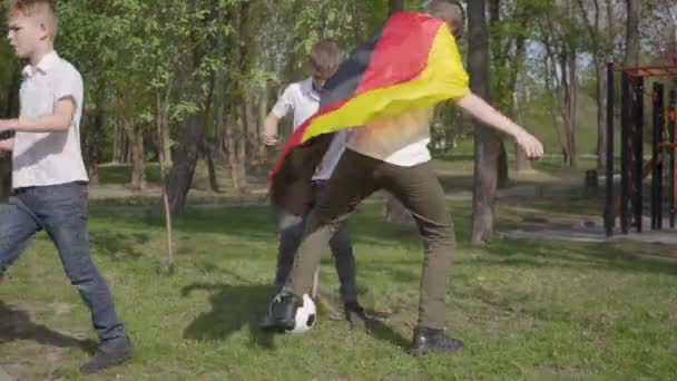 Jonge jongens voetballen in het park. Openluchtrecreatie. — Stockvideo