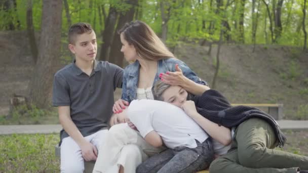 Portret van een schattige jonge moeder met jonge schattige kinderen rusten in het Park. Openluchtrecreatie. — Stockvideo