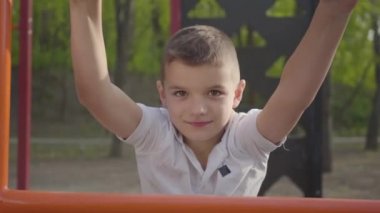 Portre küçük yakışıklı çocuk oyun yakın çekim çocuk adımları tırmanma. Aktif yaşam tarzı, kaygısız çocukluk, sevimli çocuk açık havada oynarken