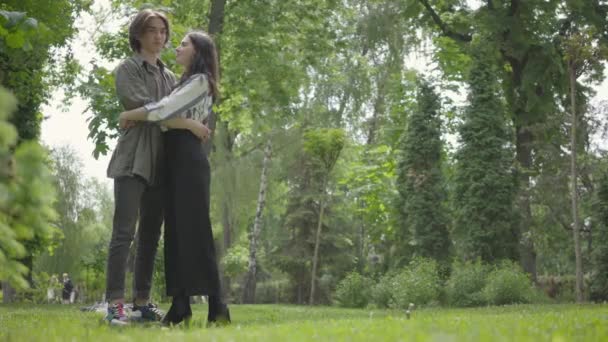 Retrato de um jovem casal amoroso abraçando descansando em um parque. Casal de data ao ar livre . — Vídeo de Stock
