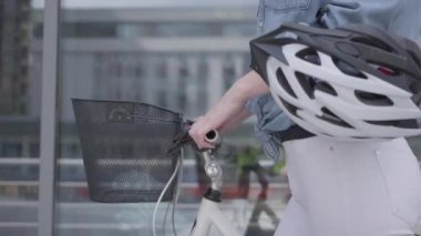Tanınmayan genç ince çekici sarışın kadın beyaz kot şehirdeki vitrinler yakınında onu bisiklet lider. Sıcak bayan açık havada vakit geçiriyor, aktif yaşam tarzı. Kamera yukarı hareket ediyor