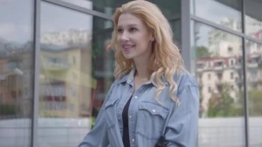 Beyaz kotlu, zayıf, çekici, sarışın bir kadın bisikletini şehrin vitrinlerine doğru sürüyor. Seksi bayan dışarıda vakit geçiriyor, aktif bir yaşam tarzı. Kamera aşağı iniyor