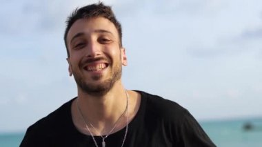 Dışarıda dudaklarını yalayan gülümseyen bir adamın portresi. Bağımsız başarılı neşeli sakallı adam hayatın tadını çıkarıyor.