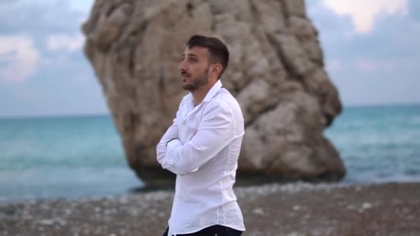 Ein nachdenklicher junger Mann spaziert an der Küste entlang. schöner bärtiger Mann verbringt Zeit in Gedanken im Freien. Zypern. Paphos — Stockvideo