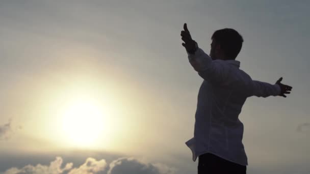 Giovane uomo gettando le mani accanto, godendo della libertà, credere al successo futuro. Buon turista sulla cima della roccia, vittoria e scopo — Video Stock