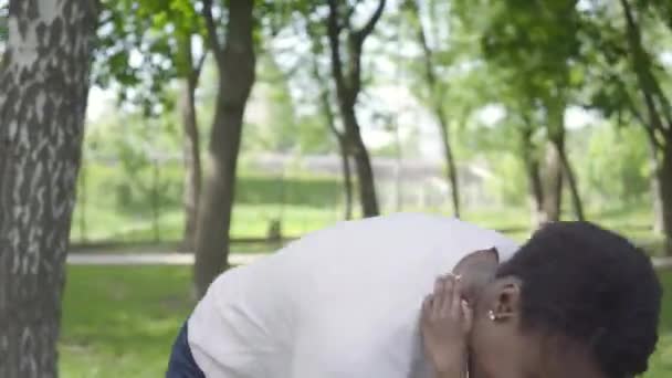 Retrato afro-americano mulher girando seu filho em seus braços no parque verde de perto, ambos rindo. Criança bonito passar tempo ao ar livre com sua mãe. Família amorosa, infância despreocupada — Vídeo de Stock