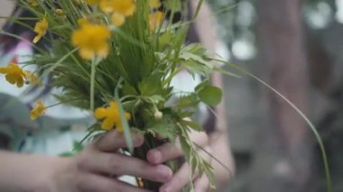 Açık havada kadın ellerinde kır çiçekleri yakın çekim.