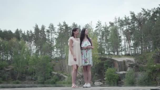 Två vackra kvinnor stående, pratar, leende. Flickor som tittar på fantastisk natur. Spektakulär utsikt. — Stockvideo