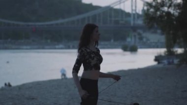 Grace emin kadın ormanda veya parkta alev ayakta bir gösteri yapıyor. Usta fireshow sanatçı akşam yangın hareket ustaca gösteren