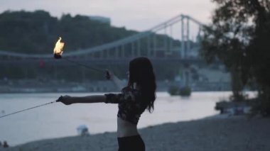 Orman veya parkta alev ayakta bir gösteri gerçekleştiren portre sevimli emin kadın. Usta fireshow sanatçı akşam yangın hareket ustaca gösteren