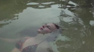 Seyşeller. Praslin Adası. Sevimli kız arkada temiz suda yatarken, rahatlatıcı. Yeryüzünde cennet. Turizm, dinlenmek, tatil, seyahat konsepti