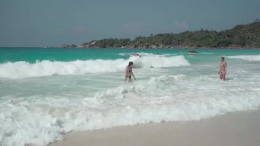 Seyşeller. Praslin Adası. Hint Okyanusu 'nda egzotik bir adada istirahat iki sevimli kız. Sahilde boş zaman ve tatiller.