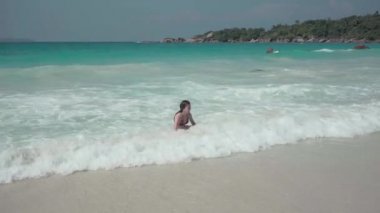 Seyşeller. Praslin Adası. Kız Hint Okyanusu 'nda egzotik bir adada dinleniyor. Sahilde boş zaman ve tatiller.