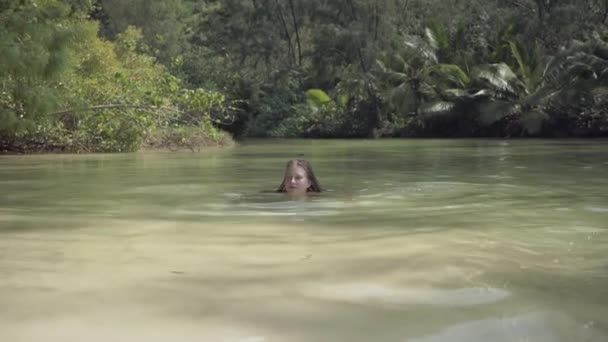 Seychellerna. Ön Praslin. Bedårande flicka simmar i vattnet på en exotisk ö i Indiska oceanen. Paradiset på jorden. Turism, Relax, semester, rese koncept. — Stockvideo