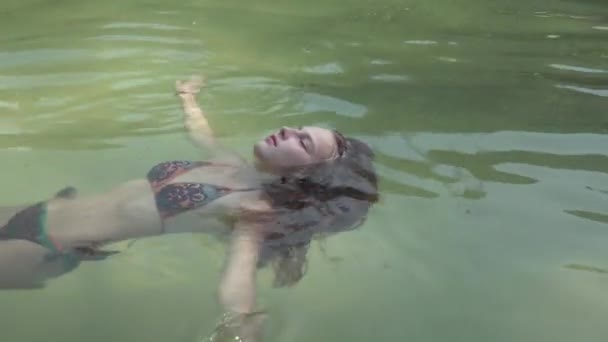 Seychelles. Praslin Island. Attractive girl lying in the clean water on her back, relaxing. Paradise on Earth. Tourism, relax, vacation, travel concept — Stock Video