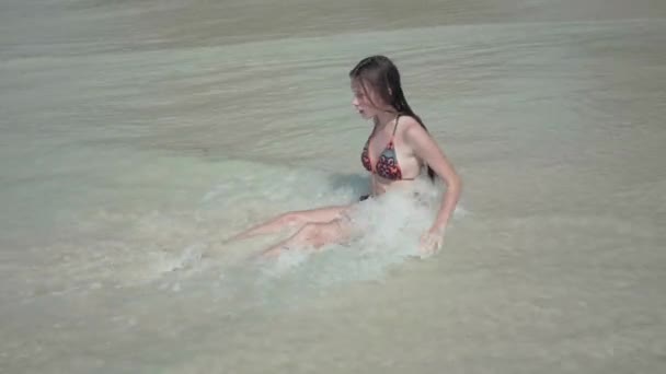 Seicheles. Ilha Praslin. Menina atraente sentado na água limpa na areia, relaxante. A senhora que descansa nas ilhas. Ondas limpas rolam na praia. Turismo, relaxar, férias, viagens — Vídeo de Stock