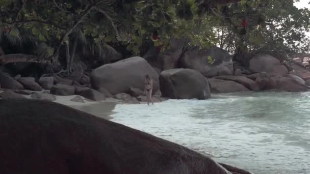 Seychellen. Praslin Island. hübsches junges Mädchen spaziert am felsigen Ufer einer exotischen Insel im Indischen Ozean entlang. — Stockvideo