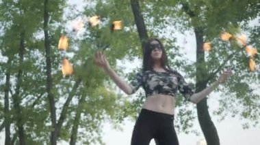 Maske dans ince kadın, nehir kıyısında ayakta ateş topu ile bir gösteri yapıyor. Ustaca fireshow sanatçı ateş ve zarif tutkulu dans hareket ustalığını gösteren