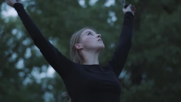 Grace mignonne femme confiante effectuant un spectacle avec la flamme debout dans la forêt ou le parc. Artiste de feu habile montrant la maîtrise du mouvement du feu dans la soirée — Video