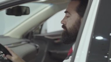 Araç içinde oturan portre çekici emin sakallı işadamı ve araba bayisinden yeni satın otomatik inceler. Araba showroom. Reklam konsepti.