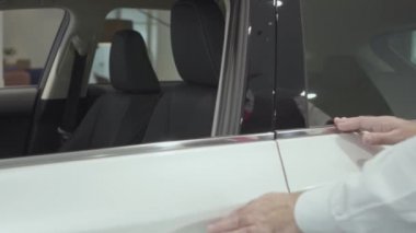 Portre çekici kendine güvenen sakallı işadamı araç oturur ve yeni otomobil Bayilik satın otomatik inceler. Araba showroom. Reklam konsepti.