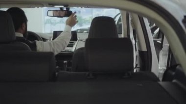 Araç içinde oturan portre çekici emin sakallı işadamı ve araba bayisinden yeni satın otomatik inceler. Araba showroom. Reklam konsepti.