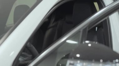 Portre çekici kendine güvenen sakallı işadamı araç oturur ve yeni otomobil Bayilik satın otomatik inceler. Araba showroom. Reklam konsepti.