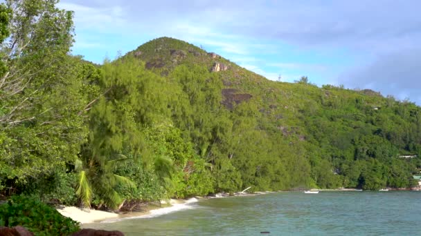 Seicheles. Ilha Praslin. Bela vista da costa montanhosa de uma ilha exótica. As árvores tropicais crescem ao longo da costa de uma ilha tropical. Movimento lento . — Vídeo de Stock