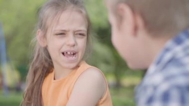 Sevimli erkek ve kız parkta oturan, konuşma ve eğlenmek Portresi. Birkaç mutlu çocuk. Aşık Komik kaygısız çocuklar