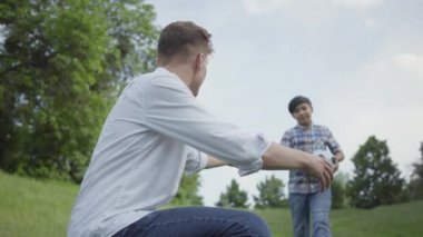 Genç babasıyla futbol oynayan çocuk. MN'ye futbol topu getiren çocuk, durumunu kontrol ediyor. Aile eğlencesi açık havada. Baba ve bir çocuk dışarıda birlikte vakit geçiriyorlar.
