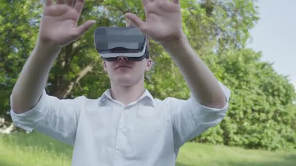 Retrato joven con auriculares de realidad virtual jugando videojuego disfrutando de la imagen realista. Tecnologías futuristas y modernas . — Vídeo de stock