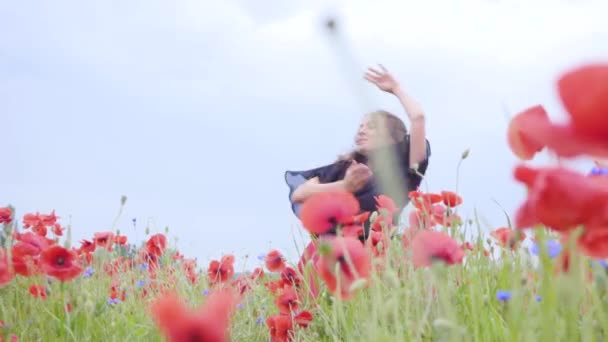 Mooi jong meisje dansen in een Poppy veld glimlachend gelukkig. Verbinding met de natuur. Vrije tijd in de natuur. Bloeiende klaprozen. Vrijheid. — Stockvideo