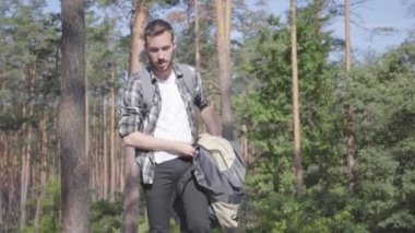 Genç adam çam ormanına çadır kuruyor. Sakallı adam dışarıda tek başına rahatlıyor. Vahşi doğayla birlik. Kamp kavramı. Boş zaman ve doğa yolculuğu..