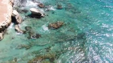 Yukarıdan video. Deniz kıyısı havadan görünümü. Sahil şeridinde uçuyor. Manzara. Akdeniz ve sahil. Kıbrıs. Şehir tatil köyü. İhA'dan ateş etme.