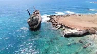 Deniz kıyısı havadan görünümü. Kırık bir gemiyle sahil şeridi üzerinde uçmak. Akdeniz ve sahil. İhA'dan ateş etmek. Kıbrıs.