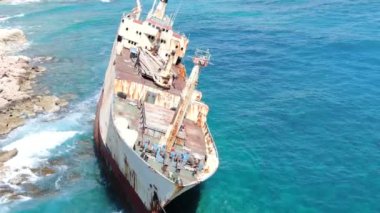 Yukarıdan video. Deniz sahilinin havadan görünümü. Kırık bir gemiyle sahil şeridi üzerinde uçmak. Akdeniz ve sahil. İhA'dan ateş etmek. Kıbrıs.