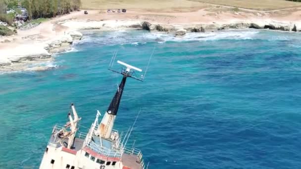 Video van bovenaf. Luchtfoto van de zeekust. Vliegen over de kustlijn met gebroken schip. Middellandse Zee en de kust. Schieten vanaf de drone. Cyprus. — Stockvideo
