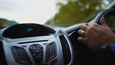 Erkek sürücü sol trafik ile ülkede sol direksiyon ile bir araba sürüyor. Yakından kapatın. Kıbrıs.